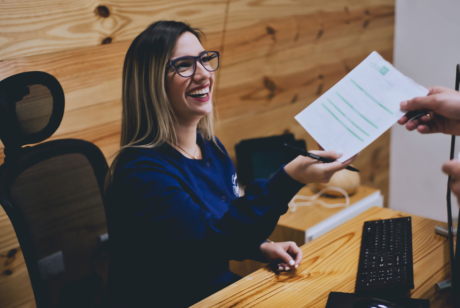 staff member helping at the front desk of the dental center with patient